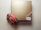 a close up of a pink bracelet and a box on a table