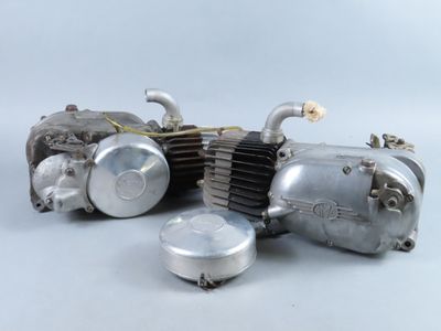 a silver motorcycle engine sitting on a white surface