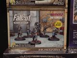 a box of fallout and a box of action figures on display
