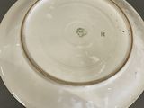 a white plate with a gold rim on a table