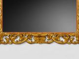 a mirror with a gold frame on a white wall