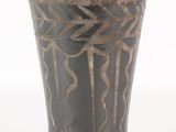 un vase noir orné d'un motif sur fond blanc