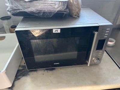 a microwave sitting on top of a counter with a bag on top of it