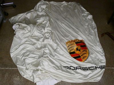 un logo Porsche sur une veste blanche posée par terre