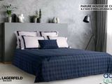 a bed that has a blue and white comforter on it