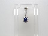 une photo d'un pendentif en pierre bleue et diamants suspendu à un présentoir transparent