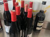 several bottles of red wine are lined up on a table