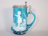 une tasse en verre bleue sur laquelle est représentée une femme