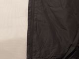 the back of a black jacket hanging on a white wall
