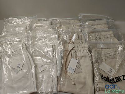 plusieurs sacs contenant des pantalons blancs posés sur une table
