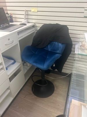 a blue chair sitting in front of a desk with a laptop on it