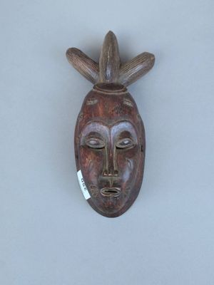 une image d'un masque en bois accroché au mur