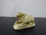 an image of a small statue of a sheep on a black surface
