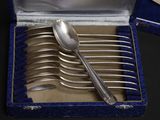 a silver spoon and spoon set in a blue box
