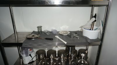 many pots and pans on the shelf in the kitchen