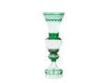 un vase en verre vert posé sur une surface blanche
