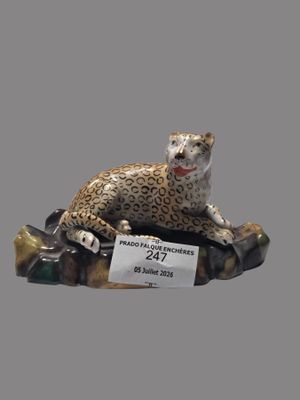 une figurine représentant un léopard assis sur un rocher