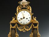 une horloge posée sur un support sur une table