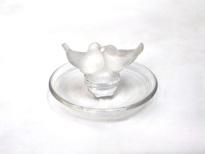 un oiseau blanc perché sur une assiette en verre