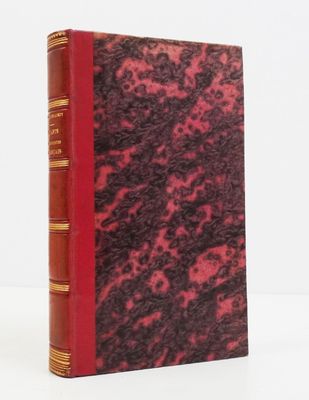 an old book with a red cover sitting on top of a white table