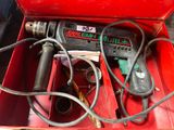 a red tool box with a drill and other tools in it