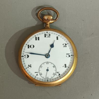 a gold pocket watch hanging on the wall