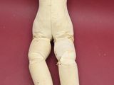 a doll that is laying down on a red surface