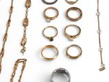 many different types of rings and bracelets laid out on a table