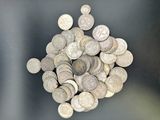 une pile de pièces d'argent posée sur une surface noire