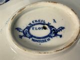 a close up of a blue and white plate with a dragon on it