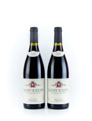 deux bouteilles de vin posées l'une à côté de l'autre sur une surface blanche