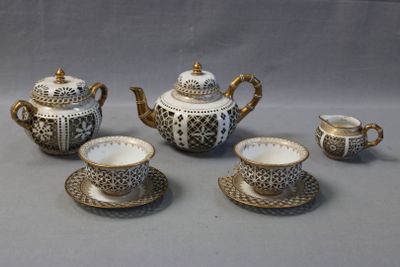 a tea set with a cup and saucer on the table