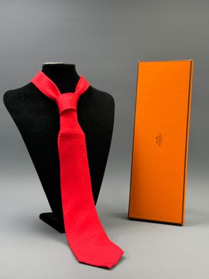 a mannequin with a red neck tie and a orange box
