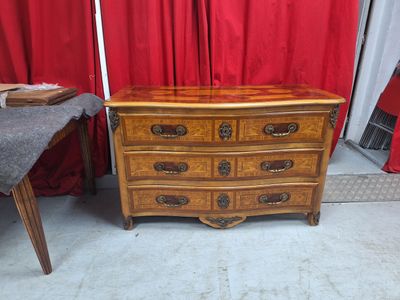 une commode en bois avec un rideau rouge derrière