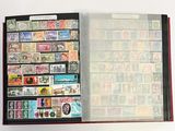 un livre ouvert, orné de timbres, posé sur une surface blanche