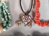three necklaces with beads and a pendant with a picture of an elephant