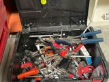 une boîte à outils remplie d'outils, posée par terre