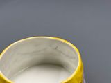 un gros plan d'une tasse jaune et violette posée sur une table