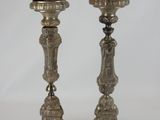 pair of antique silver candlesticks with ornate designs on them