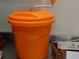 an orange bucket sitting on a counter next to a box of food