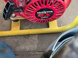 a red blower sitting on the ground next to a yellow hose