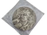 a picture of a silver coin with a man ' s face on it