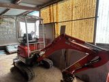 une pelleteuse rouge garée dans un garage