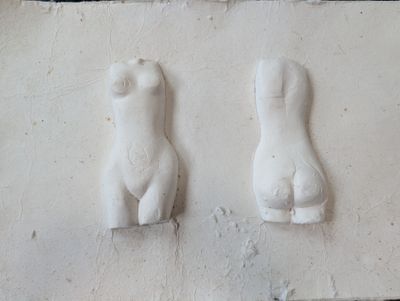 deux sculptures représentant une femme et un homme, fixées au mur