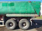 a green dump truck parked on the side of the road