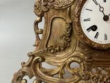 a gold clock sitting on top of a white table