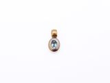a gold and blue topaze stone pendant on a white background