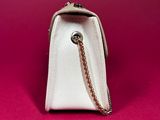 a close up of a white purse on a pink background