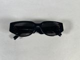 a pair of black sunglasses sitting on top of a white table