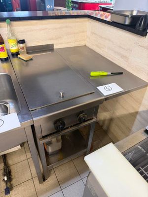 a kitchen with a stove, sink, and a stove top